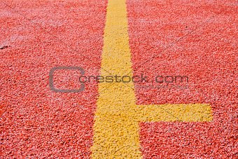 Yellow line on red playing field. Copy space. Sport texture and background
