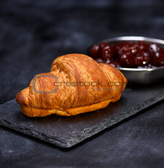 baked croissant on a black graphite background