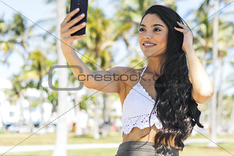 Trendy brunette taking selfie in sunshine