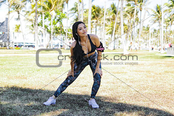Content ethnic woman stretching in park