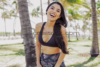 Ethnic laughing sportswoman looking at camera outside