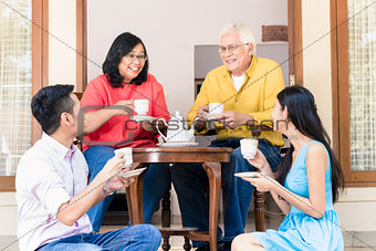 Young man and woman visiting parents at home in the afternoon