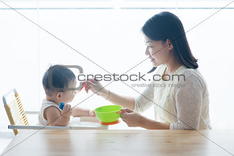 Mother feeding toddler.