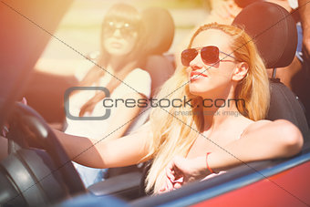 Young woman in cabriolet car departs for the summer holidays