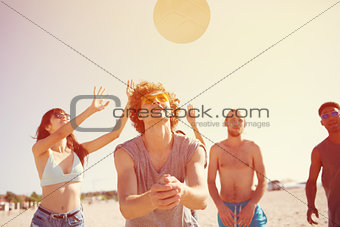 Group of friends playing at beach volley at the beach