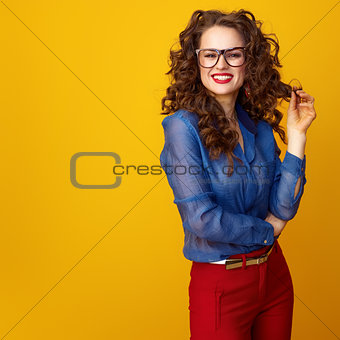 smiling trendy woman isolated on yellow background in glasses