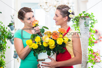 Women in flower store enjoying the roses