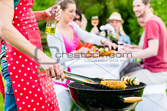 Man grilling meat and vegetables on garden party