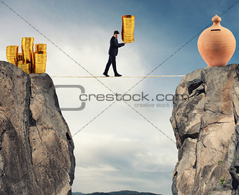 Businessman moves a pile of coins to a moneybox. concept of difficulty to saving money