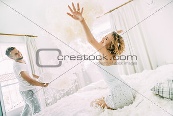 Love happy couple in the bedroom with feathers