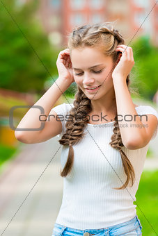 beautiful girl with two braids corrects hands hair, close-up por
