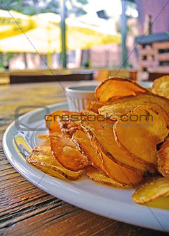 Plate of home made potato chips with sauce.