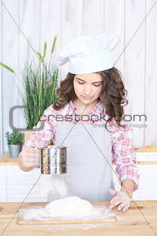 Adding flour. Test Preparation. Girl in kitchen. Little cook