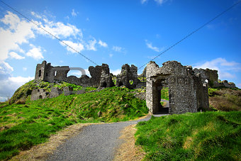 Stone castle ruins in the green grass of Ireland