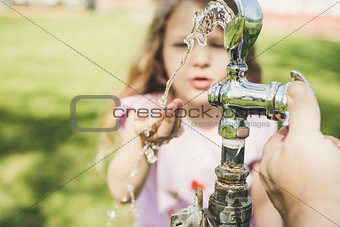 Little girl at water fountain