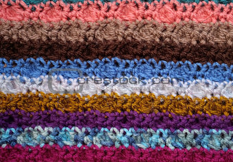 Background of crocheted stitches in multi-coloured stripes