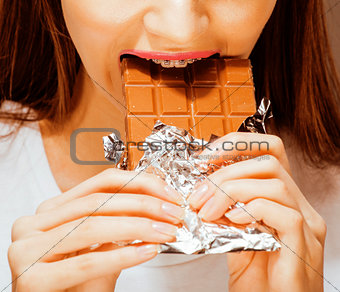 woman eating chocolate, close up hands with manicure french nail