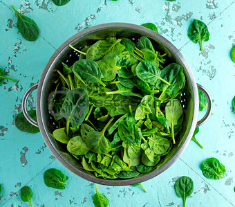 green spinach leaves in an iron colander