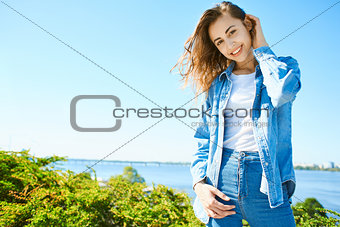 portrait of a young attractive woman on the blue sky background