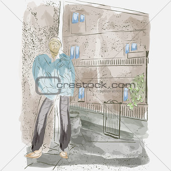 A guy poses against the background of an old house