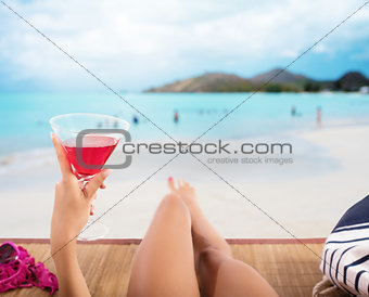 Girl relaxes at the beach with a cold drink