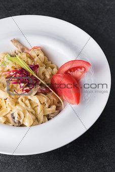 Italian paste of carbonaria with mushrooms with cream sauce on a white plate