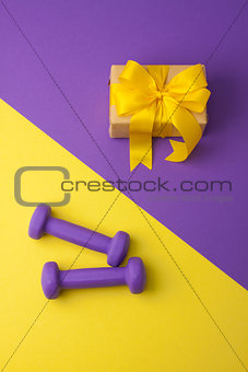 Sport flat lay composition with dumbbells and gift box