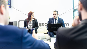 Business people sitting at working meeting in modern corporate office.