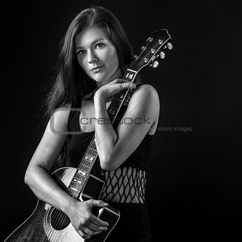 Beautiful young woman holding acoustic guitar