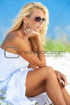 Beautiful Thoughtful Sad Blonde Woman in Sunglassesd At Beach