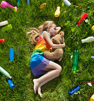 Young girl sleeping with her teddy bear in the plastic littered 