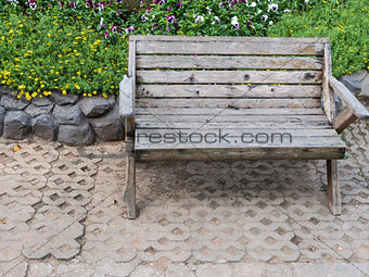 Wooden bench near the flowerbed.