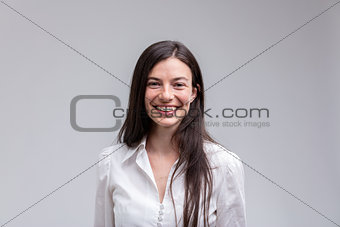 Young long-haired smiling woman in white shirt