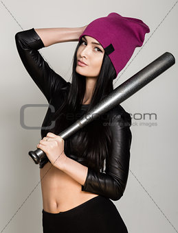 Cool hipster woman holding baseball bat. Beautiful university student looking at camera smiling happy