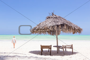 Lady walking to the sea oat white sandy tropical beach of Paje, Zanzibar, Tanzania.