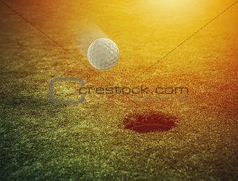 Golf ball near the hole in a grass field