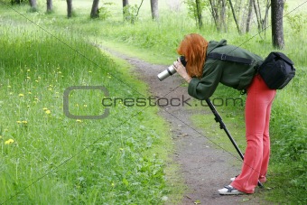 girl taking macro photo in park