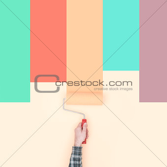 Decorator painting colorful stripes on a wall