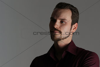 Face of handsome man with fashionable hairstyle half closed in shadow