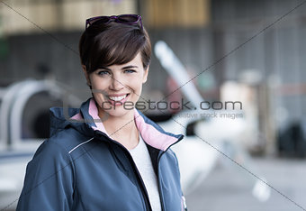 Smiling female pilot posing in the hangar