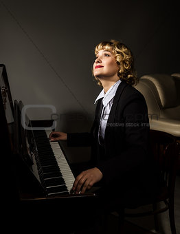 beautiful woman in a business suit playing the piano.