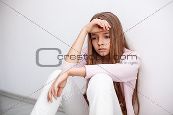 Young teenager girl having a heartache - sitting on the floor by