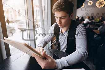 Young man with tablet pc computer at cafe