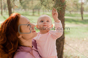 in the Park mom shows her daughter fir branches