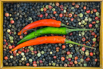 parallel chili pepper green red pod on background mix of polka dots black red white with wooden frame container