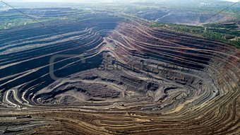 Aerial view of opencast mining quarry with lots of machinery at work. Mining-dressing quarry