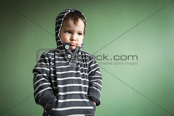 gloomy cute little boy holding hands in pockets