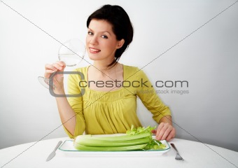young woman having her breakfast with water and celery