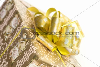 detail of a gift box with golden ribbon and bow
