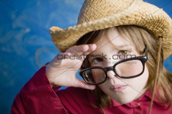 Little girl with glasses and a straw hat